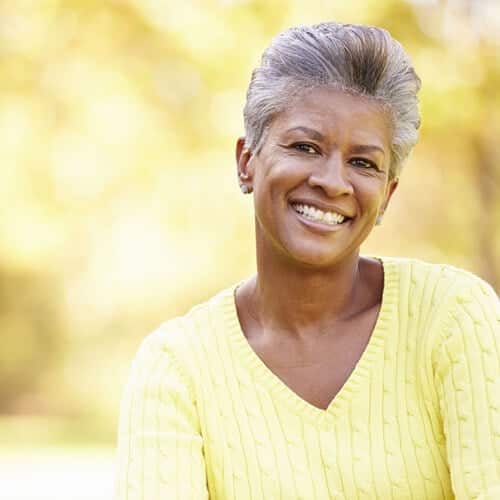 smiling elderly woman in fall colors in the park