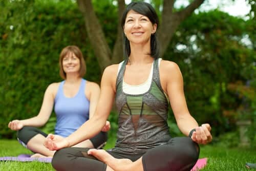 A woman doing yoga who is happy with her smile