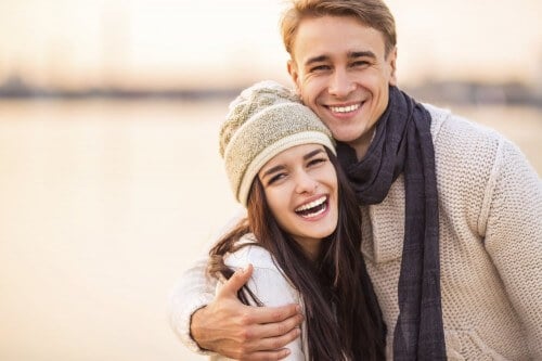 young couple hugging and smiling on beach